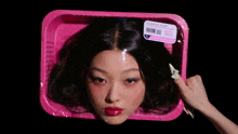 a woman 's head is in a pink plastic container with a label that says us national foods