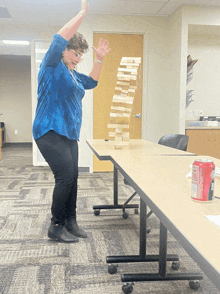 a woman in a blue shirt is playing jenga