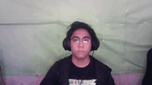 a man wearing headphones and a black shirt that says mark