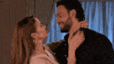 a man and a woman are kissing and the woman is holding the man 's neck