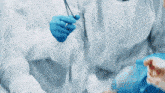 a surgeon is holding a pair of scissors in his hands while a nurse holds an oxygen mask .