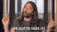 a man with long hair is saying we gotta take it