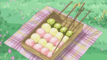 a wooden box filled with pink and green balls on sticks is sitting on a blanket .