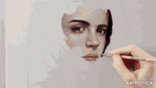 a painting of a woman 's face is being made in animotica