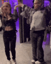a man and woman are dancing in a room with purple lights