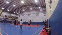 a group of people are playing basketball in a gym with a sign that says molten