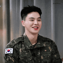 a young man in a military uniform has a korean flag patch on his sleeve