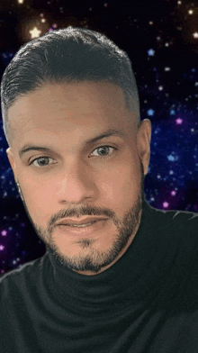 a man with a beard wearing a black turtleneck looks at the camera