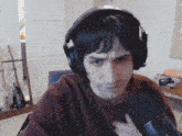 a man wearing headphones is holding a microphone and making a funny face .