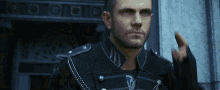 a man with a beard is wearing a black jacket and gloves