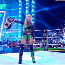 a woman in a wrestling ring holding a championship belt with the next thing written on the bottom