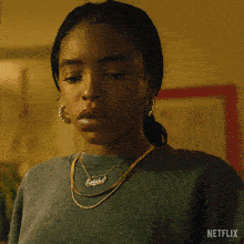a woman is wearing a necklace and earrings and says " fuck "