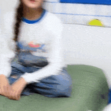 a blurry picture of a person sitting on a bed with a white shirt on