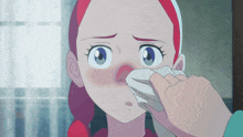 a person wipes a girl 's nose with a tissue