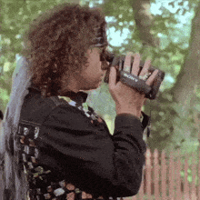 a man is holding a sony camera on his wrist