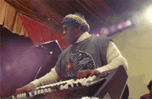 a man in a polka dot shirt is playing a piano