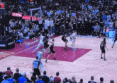 a basketball game is being played in front of a crowd with a michelle obama ad on the wall
