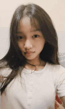a girl with long hair is wearing a white shirt with buttons on it