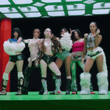 a group of women are standing on a stage and one of them has a furry tail