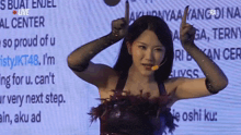 a woman is giving a thumbs up in front of a screen that says live