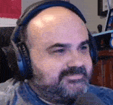a man with a beard is wearing headphones and a microphone .