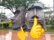 a statue of a man giving a thumbs up next to a statue of a woman covering her mouth