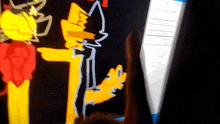 a person is pointing at a drawing of a yellow cat