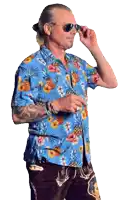 a man wearing a blue shirt with pineapples and flowers on it
