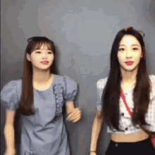 two women are standing next to each other and holding hands .