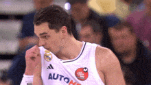 a man wearing a white jersey that says autoh on it