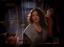 a woman with curly hair is standing in front of a man in a red shirt .