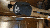 a man wearing a quiksilver shirt stands in a hallway