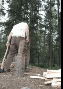 a man wearing a white shirt that says " win or lose " is cutting wood