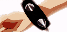 a close up of a person 's wrist with a black bracelet with spikes on it