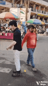 a man in a red shirt holds the hand of another man