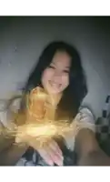 a girl is taking a selfie with a glowing object in her hands