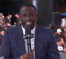 a man in a suit is holding a microphone that says world sports on it