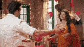 a man and a woman are hugging each other in a room decorated with hearts .