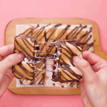 a person holding a piece of chocolate covered marshmallow