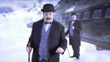 two men are standing in front of a train that says ' switzerland ' on the side