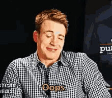 a man wearing a plaid shirt with the word oops on it