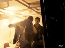 a group of people standing in a dark room with a rbd.gif watermark on the bottom