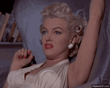 a woman in a white dress is making a funny face with her arms outstretched
