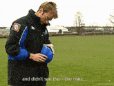 a man in a black and blue jacket is holding a blue ball and says " and didn 't see the the risks "