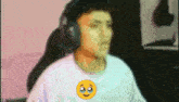 a man wearing headphones and a white shirt with an emoji on it