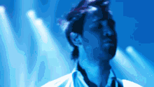 a blurry picture of a man in a white shirt with a blue background