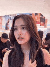 a woman in a black dress is standing in a crowd