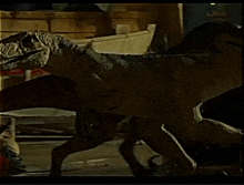 a statue of a dinosaur is standing in front of a wooden box