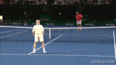 two tennis players on a tennis court with rolex advertisements behind them
