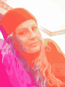 a woman wearing a red beanie and headphones looks at the camera with a photo lab logo in the corner